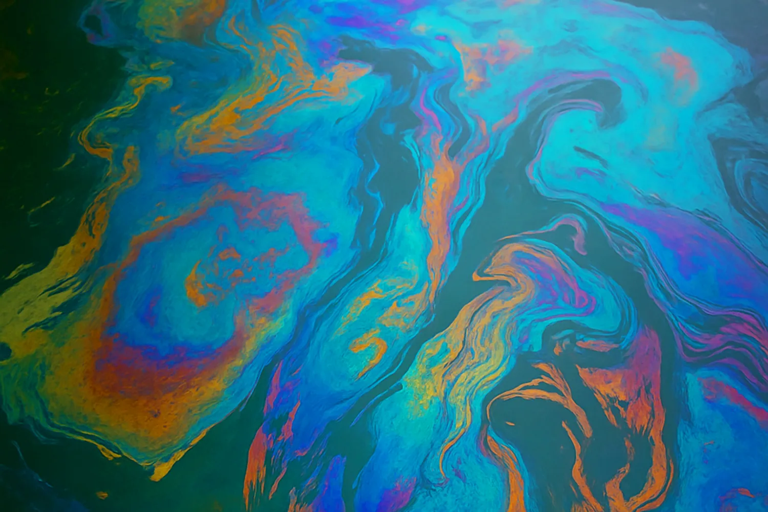 An oil sheen spreading across a water surface
