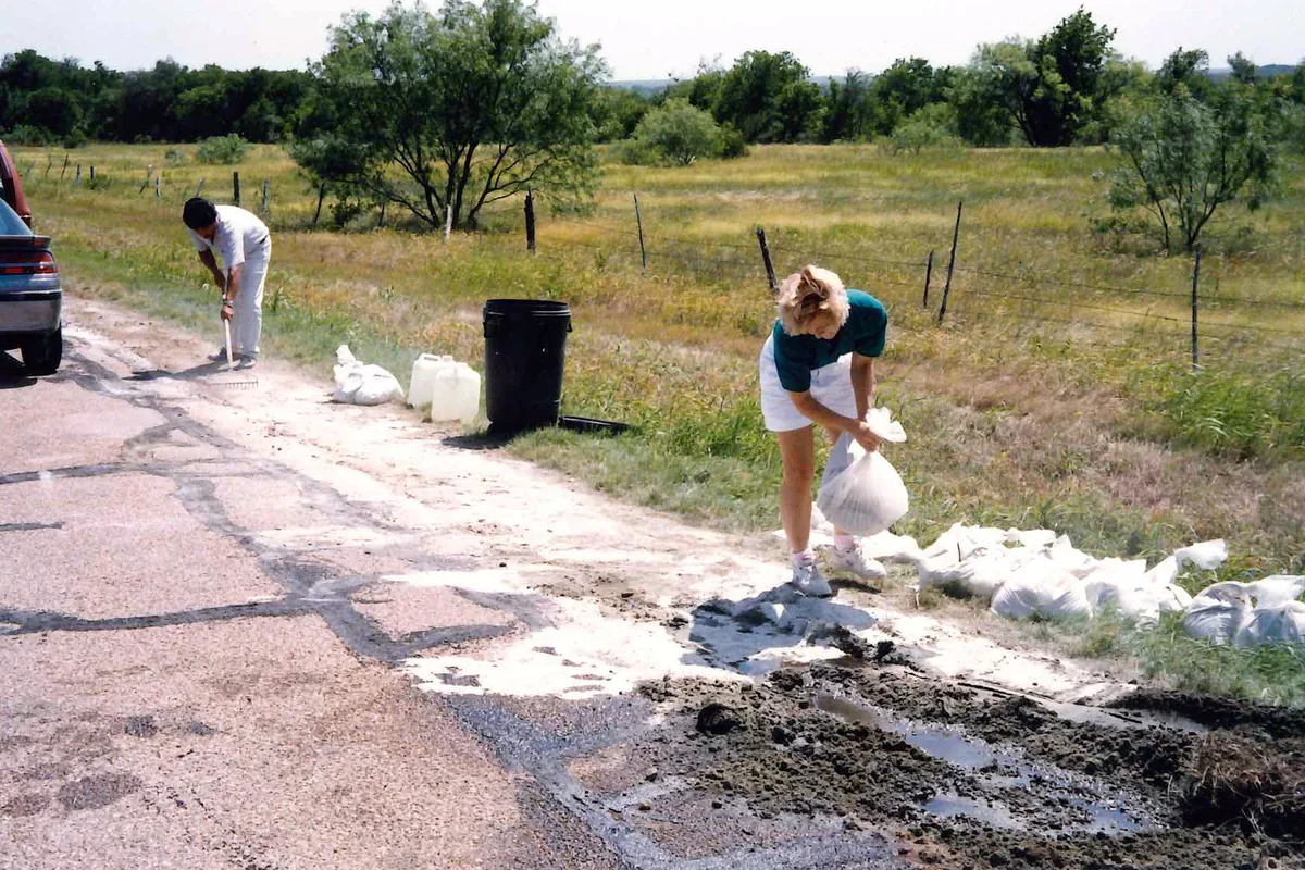 Applying bioremediation product to an oil spill on a roadside